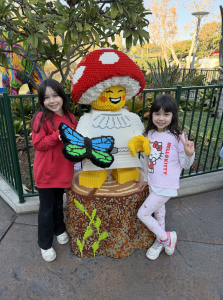 Two young girls with mushroom girl Lego at Legoland.